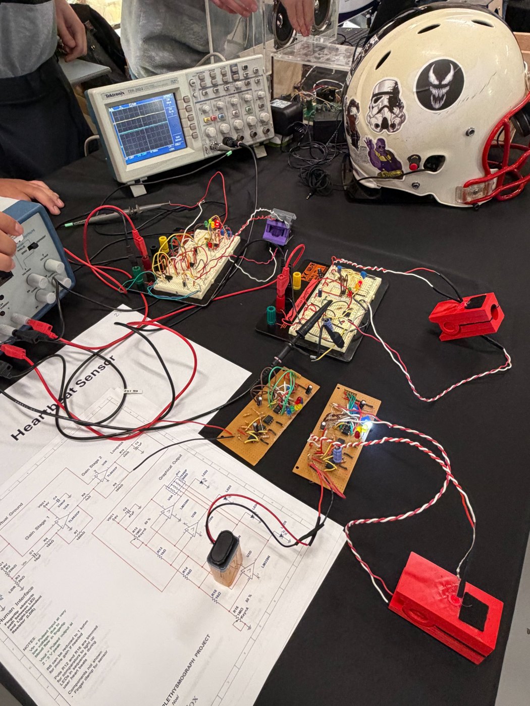 Pulse oximeter project workbench with an oscilloscope, breadboard prototypes, and circuit-board assemblies